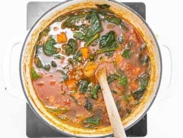 Step 3 Stirring fresh spinach into the soup until wilted.