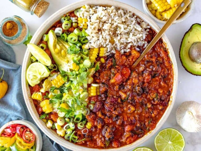 Step 4 Bowl of chili with beans served hot with rice avocado and lime wedges.