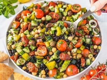 Step 4 Serving Mediterranean bean salad on a platter and Louise scooping it up with a spoon.