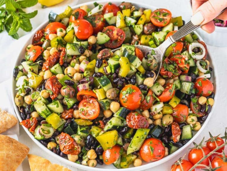 Step 4 Serving Mediterranean bean salad on a platter and Louise scooping it up with a spoon.