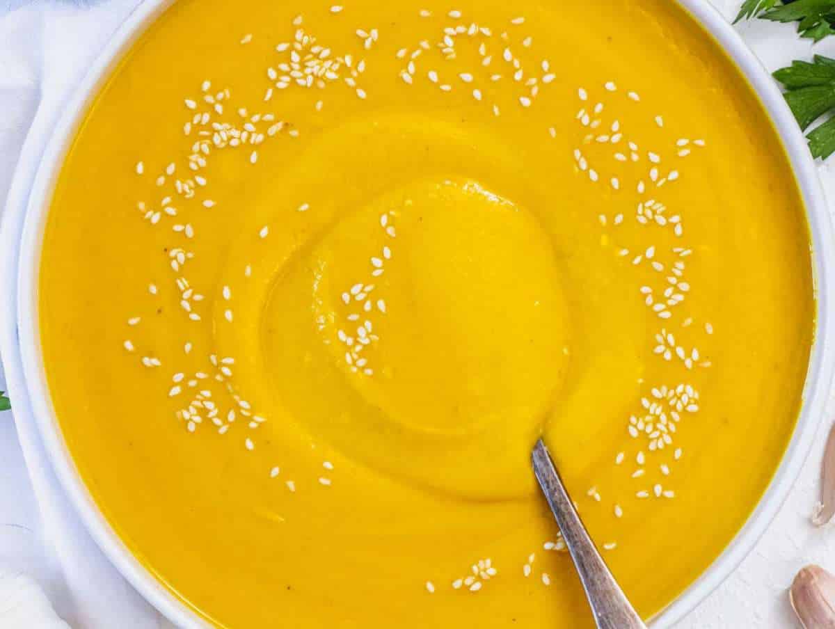 Step 5 Coconut pumpkin soup served in bowls with fresh lime juice squeezed on top.