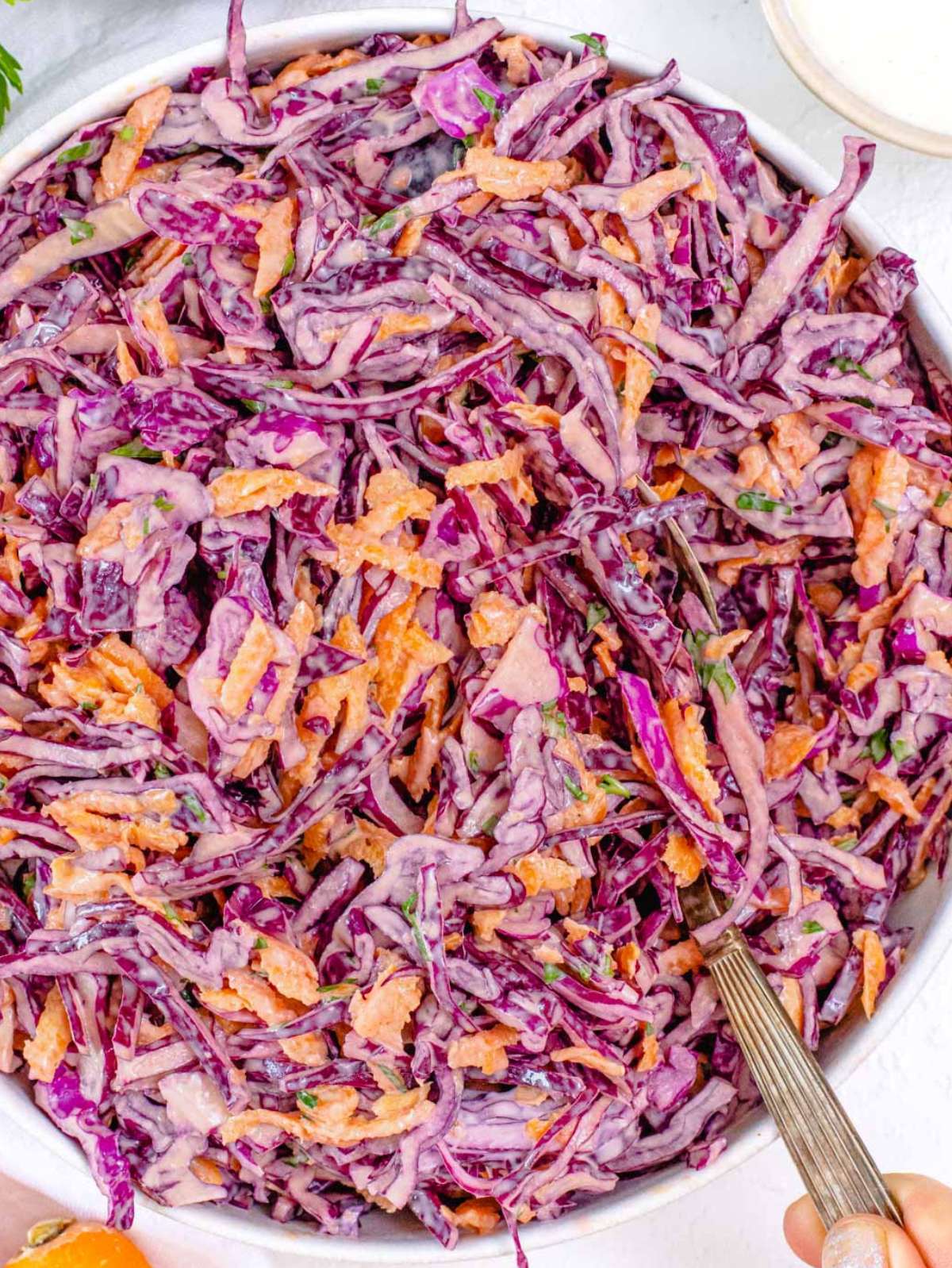 Top down view of Greek Yogurt Cabbage Slaw showing colorful shredded veggies and creamy dressing.
