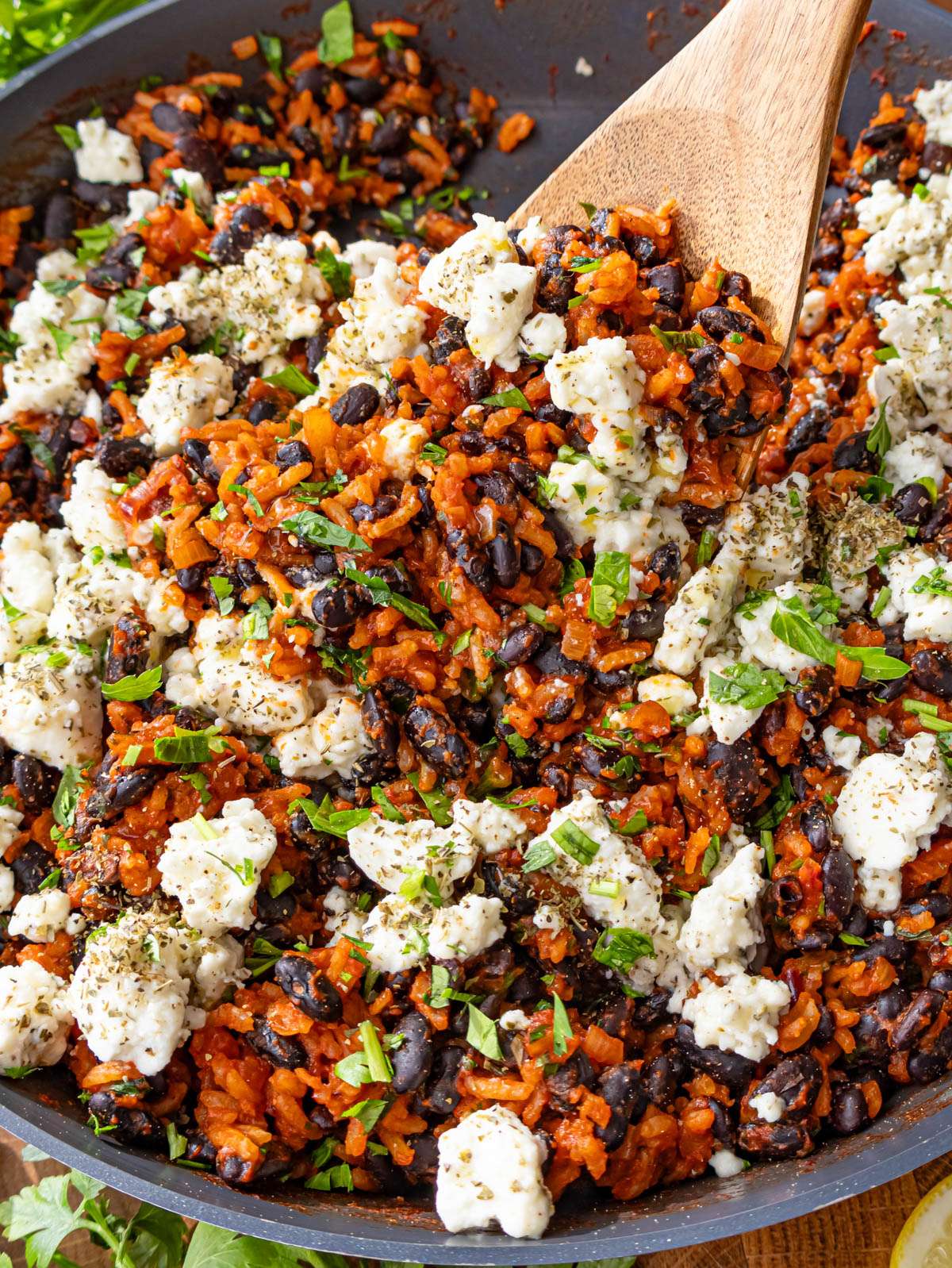 Close up of Mediterranean black beans and rice with marinated feta and fresh parsley.