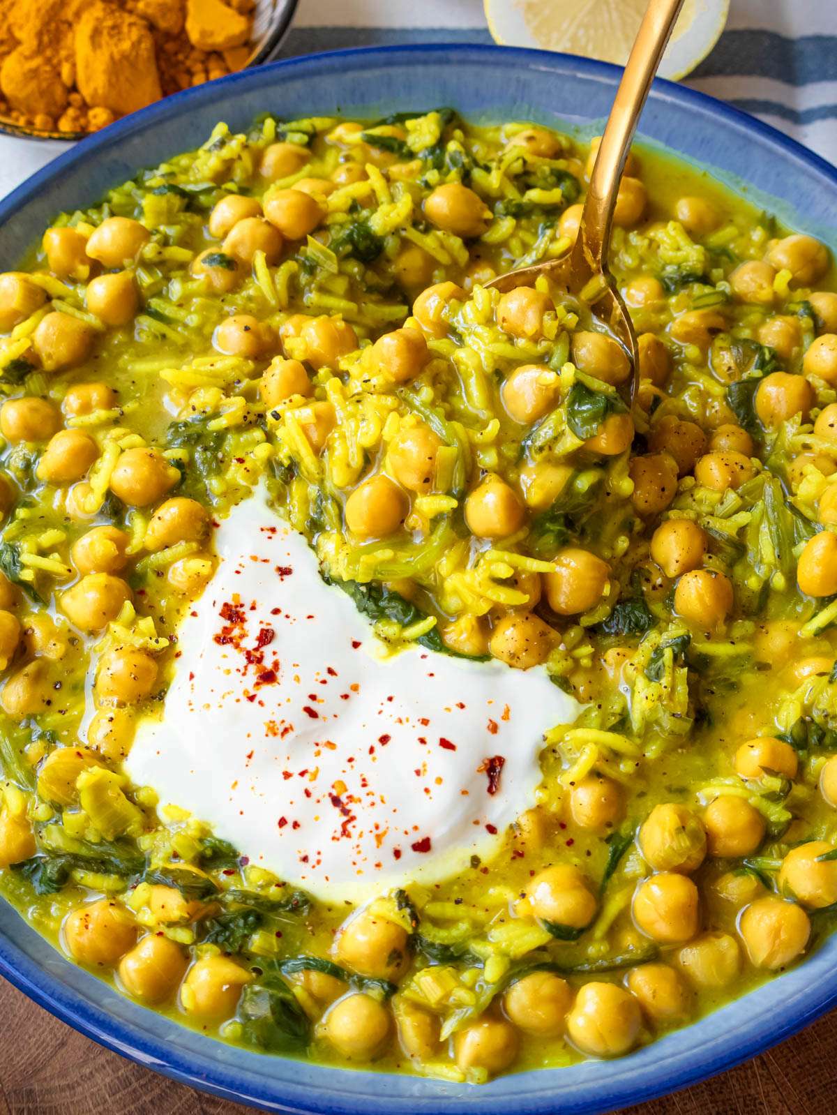 Close up of creamy turmeric rice with chickpeas spinach and Greek yogurt for a wholesome meal.