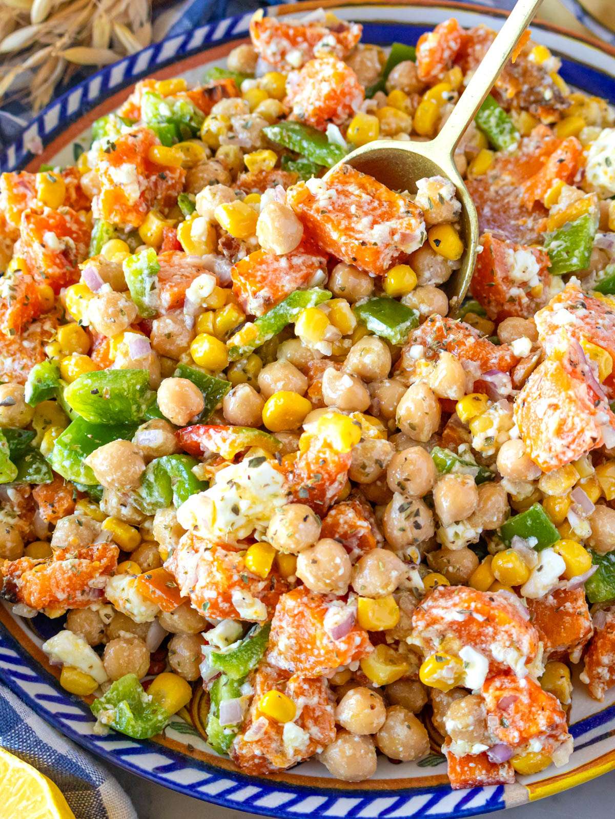 Close up of dense chickpea sweet potato salad with feta and honey mustard dressing.