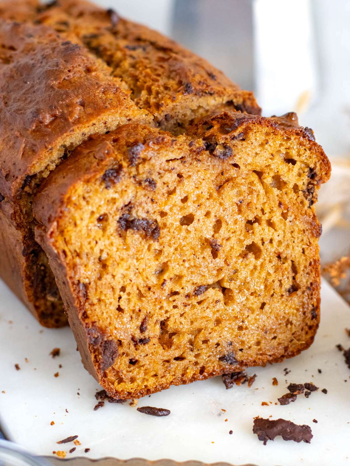 Close-up of moist sweet potato bread with dark chocolate chunks and golden crust.