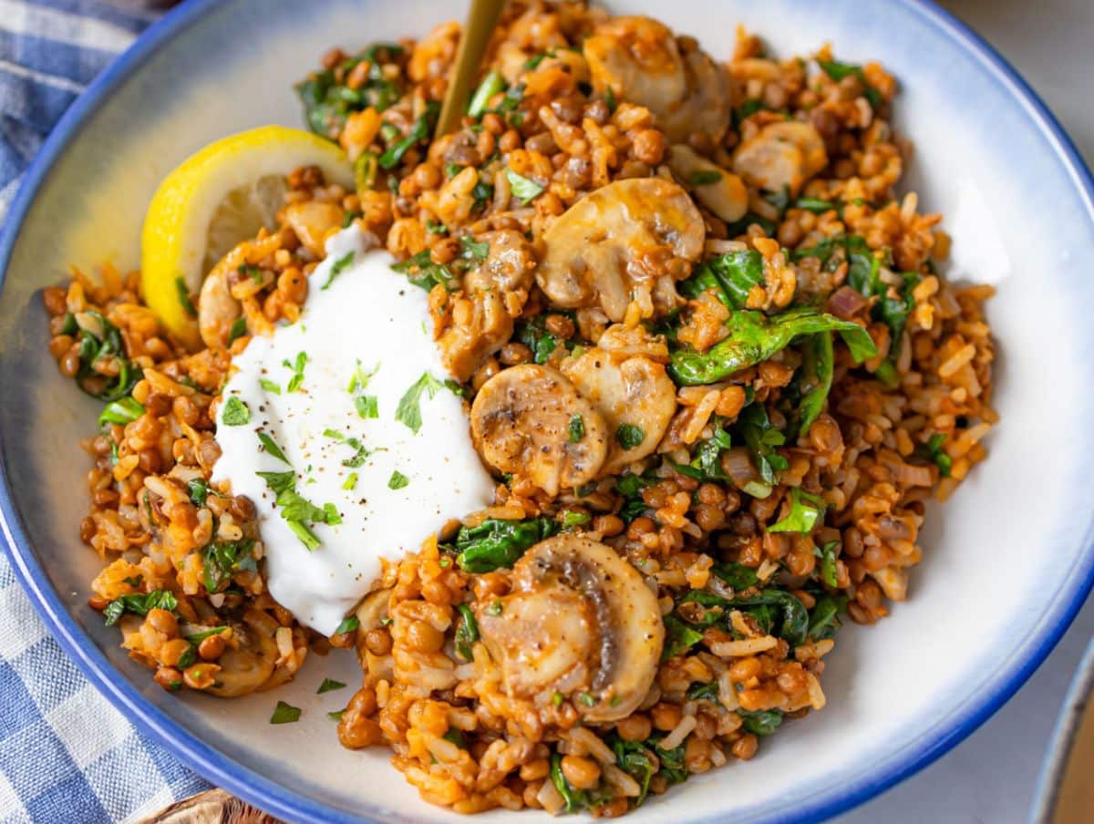 Feature image Mediterranean mushroom and rice stir fry topped with Greek yogurt and lemon wedges.