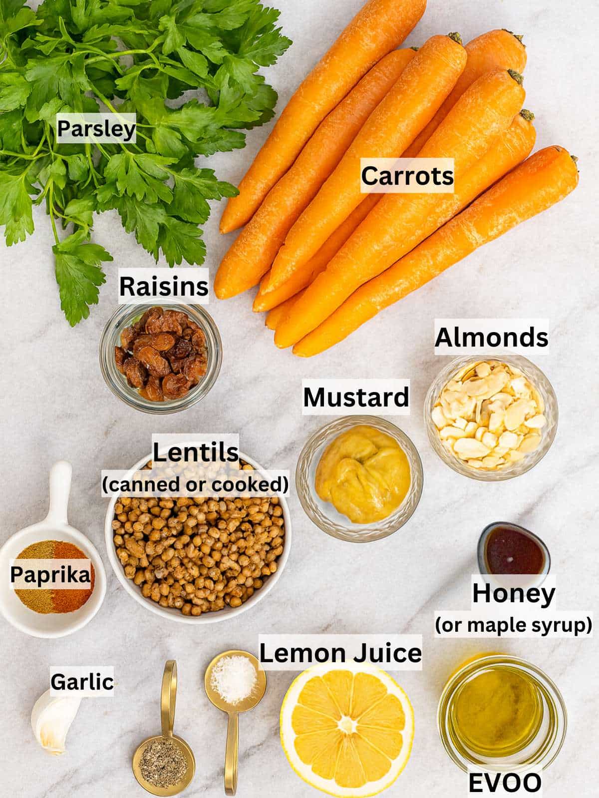 Fresh carrots lentils herbs nuts and dressing ingredients arranged for Mediterranean carrot salad.