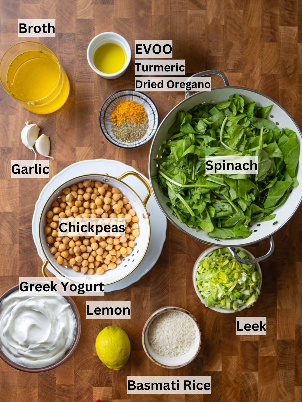 Fresh ingredients for turmeric rice including leek garlic chickpeas spinach turmeric and rice on a table.