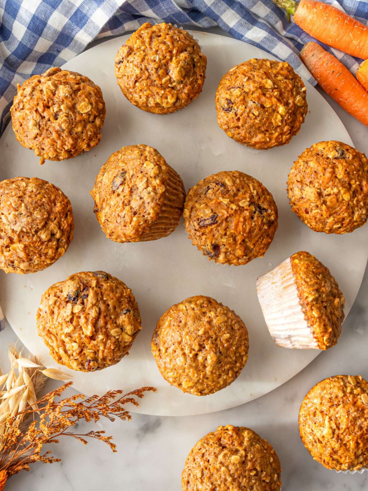 Freshly baked oil free carrot muffins displayed on a marble table for wholesome morning treat.