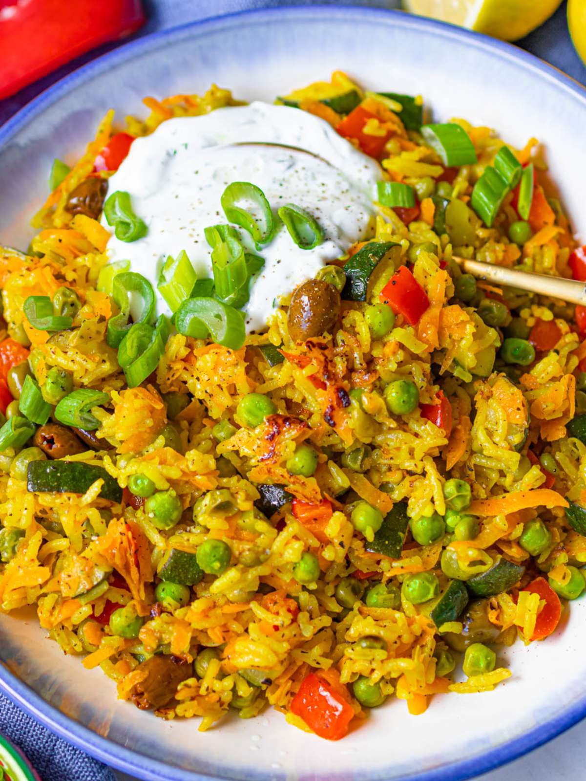 Golden Mediterranean stir fry close up with veggies rice turmeric and Greek yogurt topping.