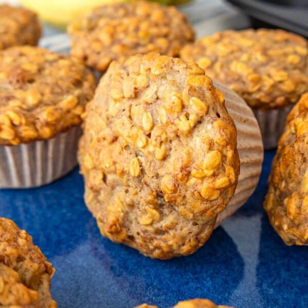 Healthy banana oatmeal muffins made with oats and Greek yogurt on a blue platter.