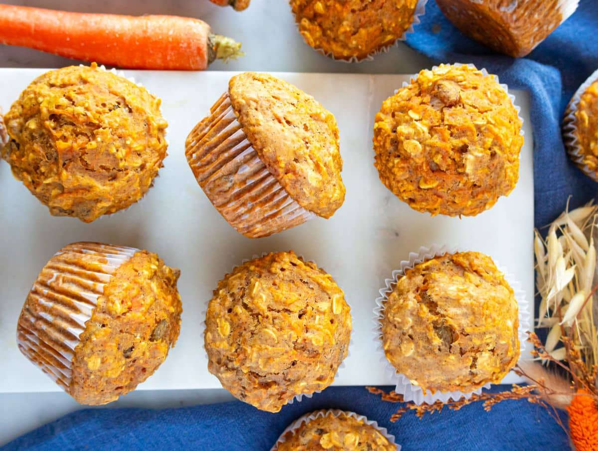 Healthy oil-free carrot muffins on breakfast table with a blue cloth.