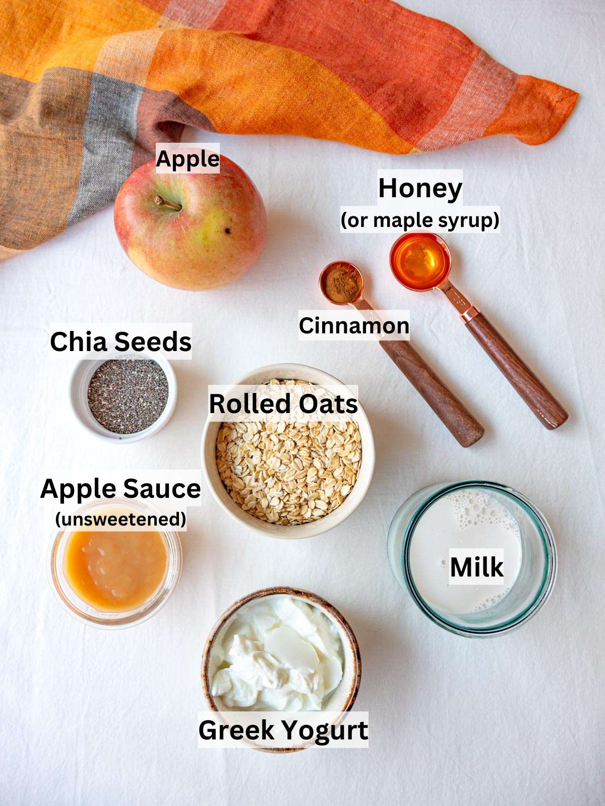 Ingredients for apple cinnamon overnight oats arranged neatly on a kitchen table.
