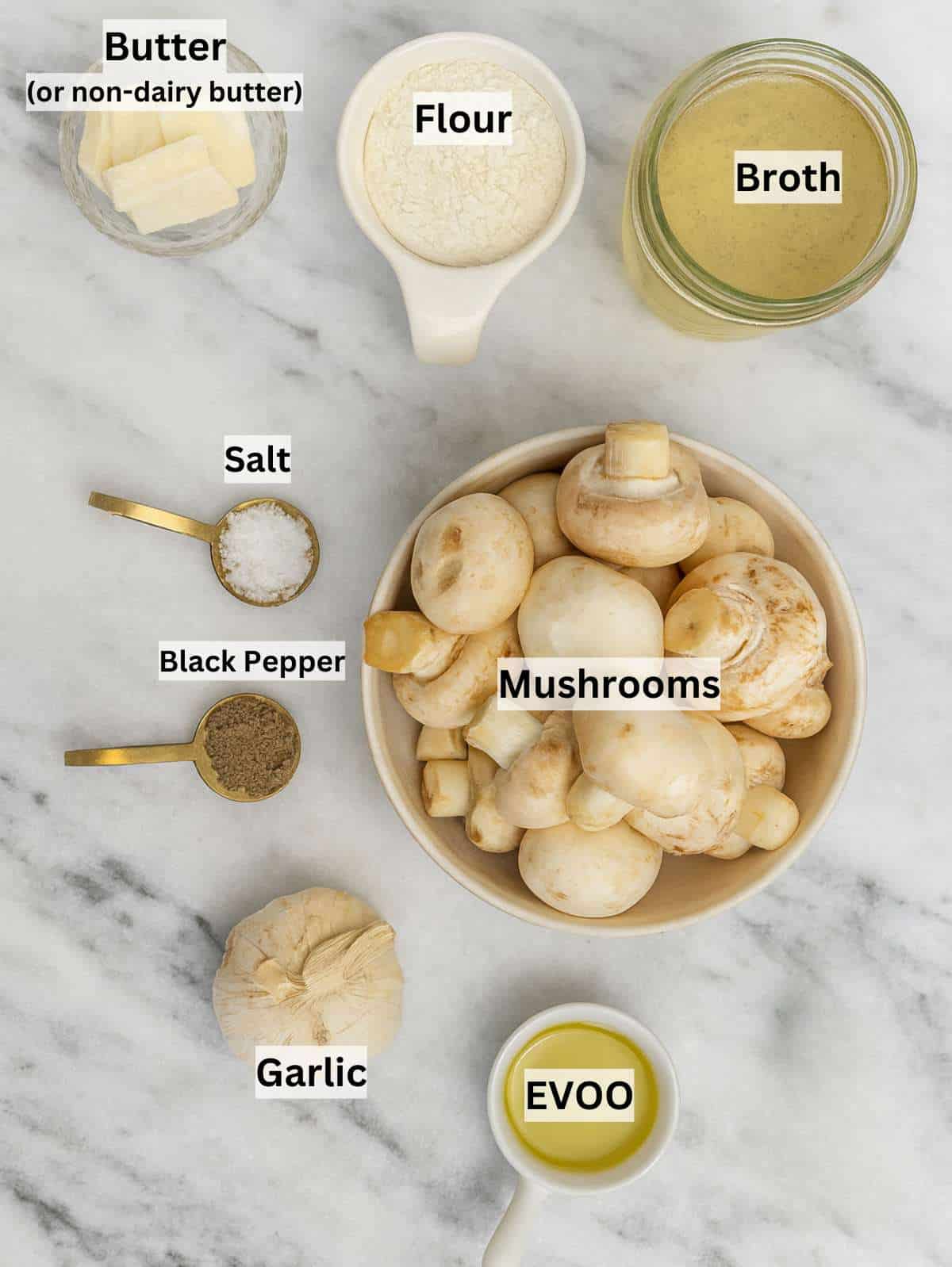 Ingredients for mushroom sauce arranged on table with mushrooms broth and garlic.