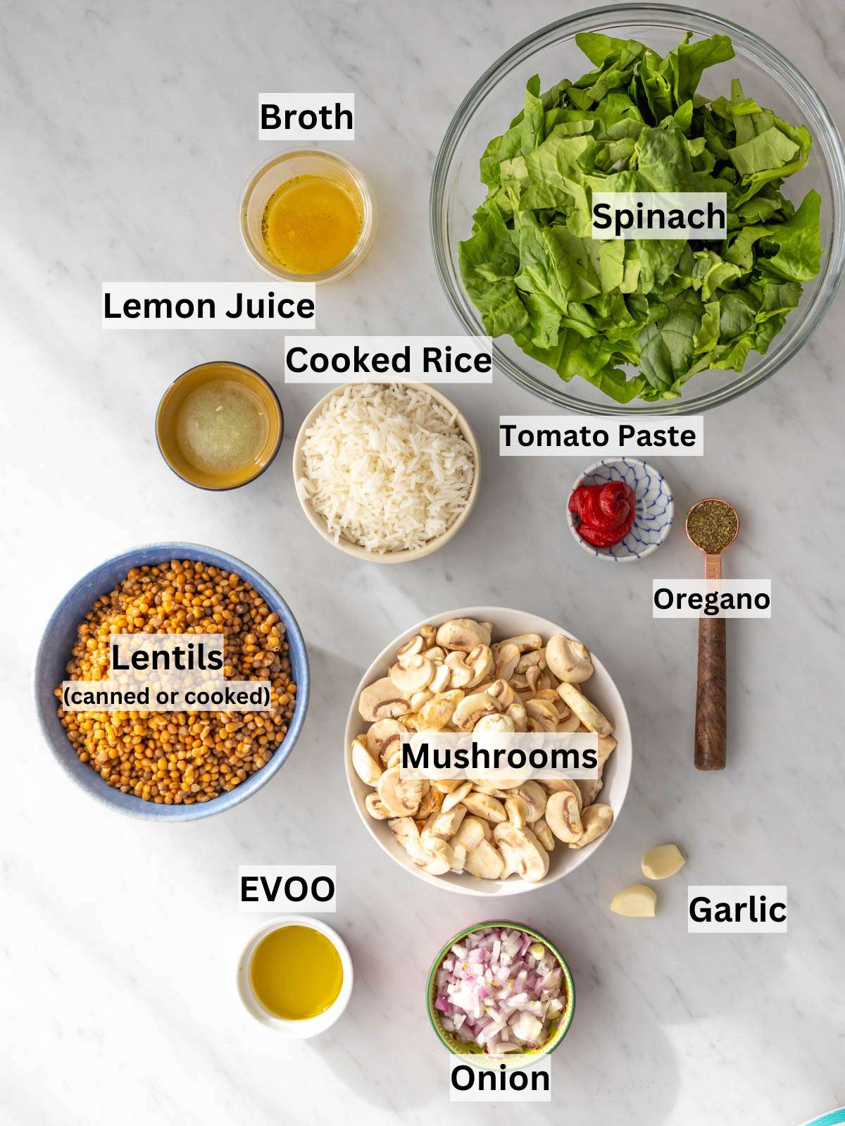 Ingredients shot mushrooms lentils rice spinach and sauce components arranged on table.