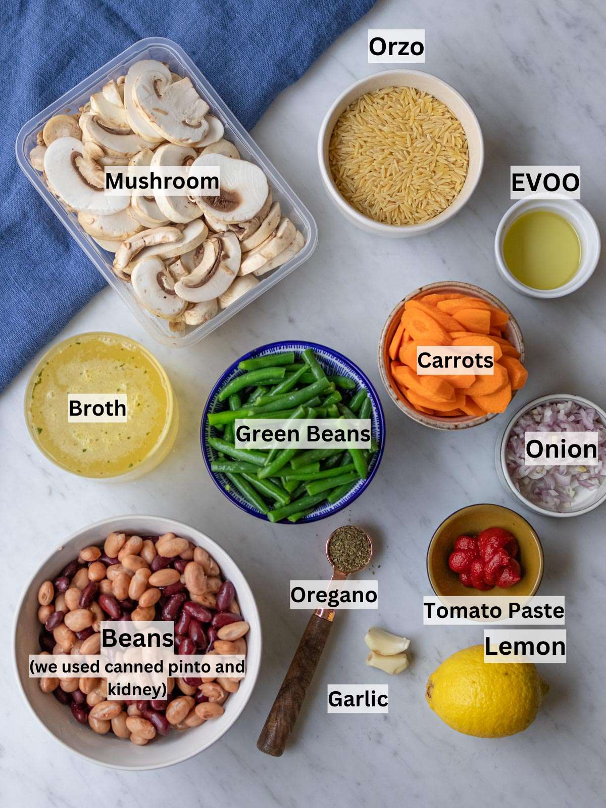 Ingredients shot vegetables beans broth and orzo arranged for easy Mediterranean soup recipe.