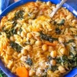 One skillet chickpea orzo recipe with kale carrots and tomato broth in a bowl.