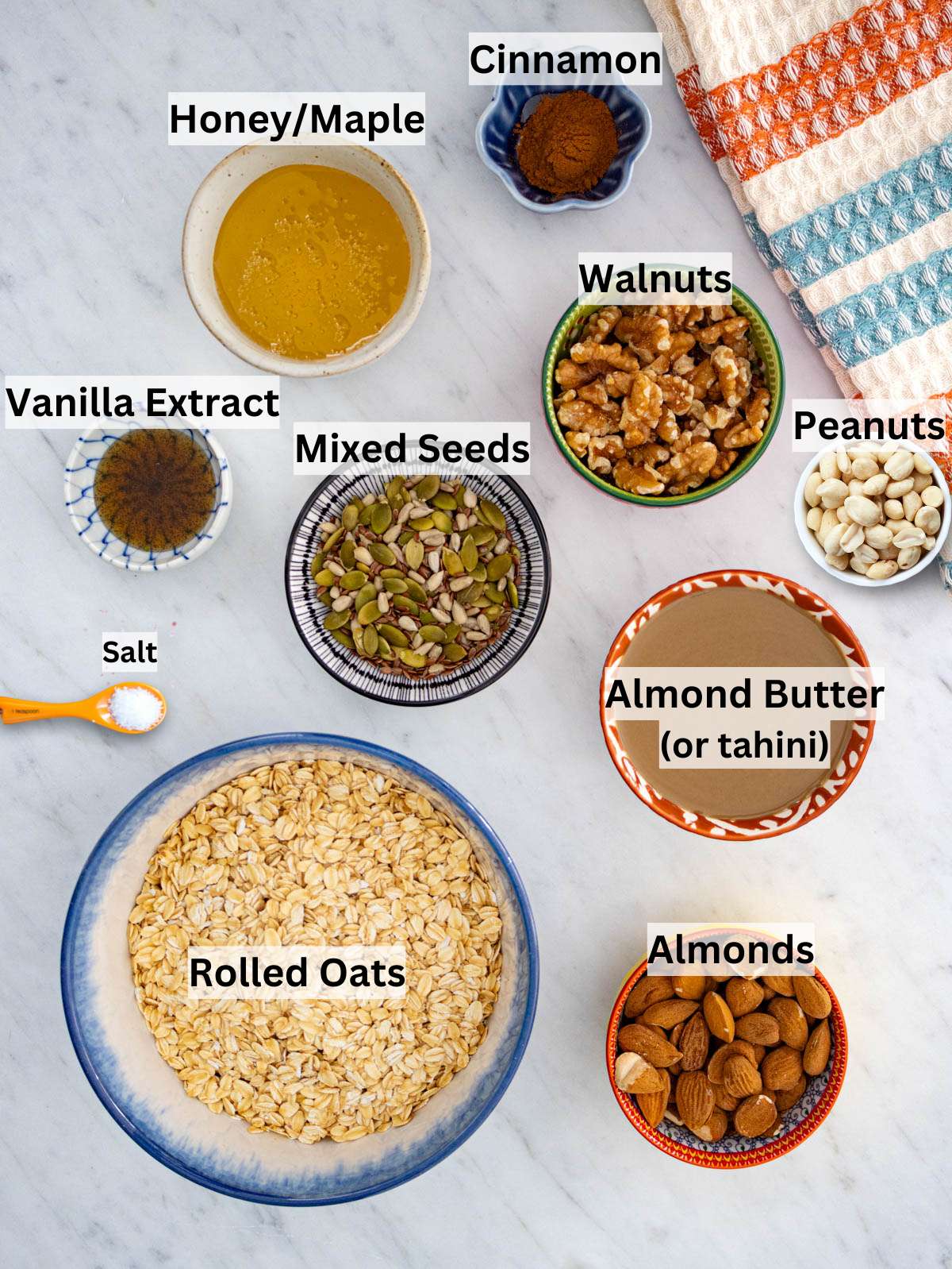 Rolled oats almond butter nuts and seeds arranged for making crunchy oil free granola.