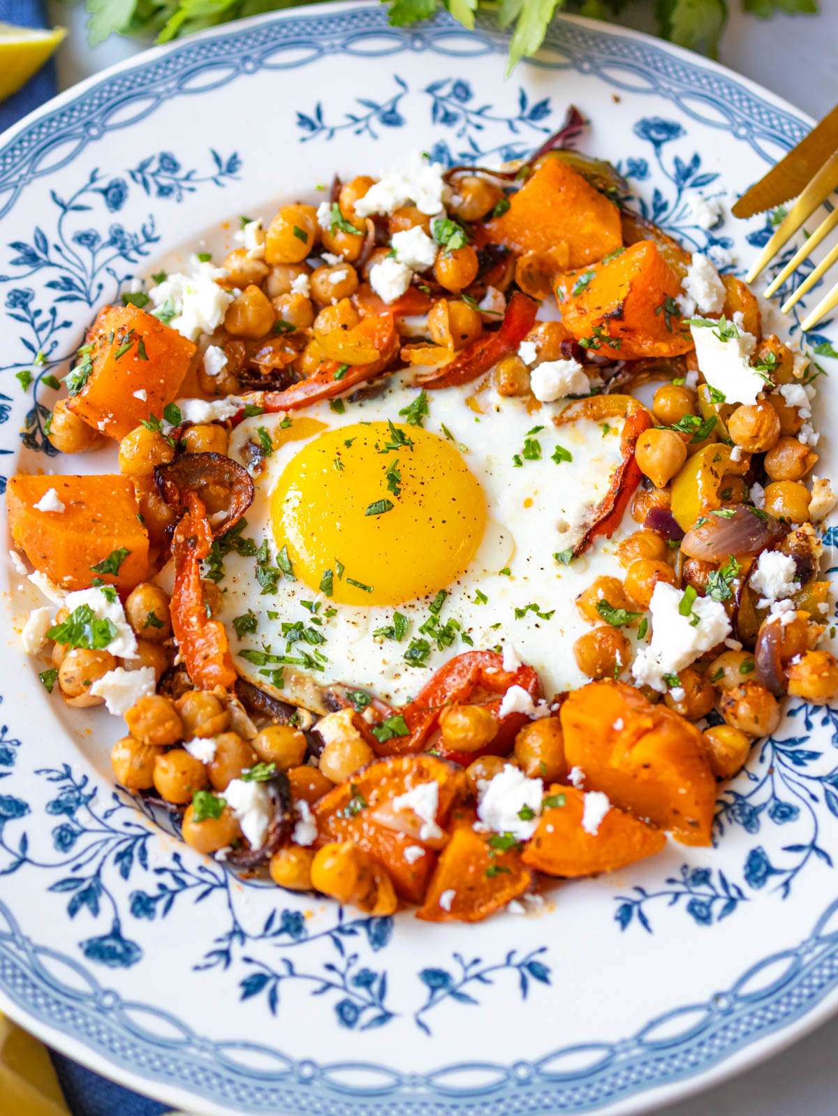 Serving sweet potato and chickpea bake on a plate with crumbled feta.
