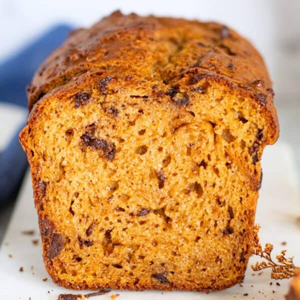 Sliced sweet potato bread with dark chocolate chunks showing moist texture and warm golden crumb.