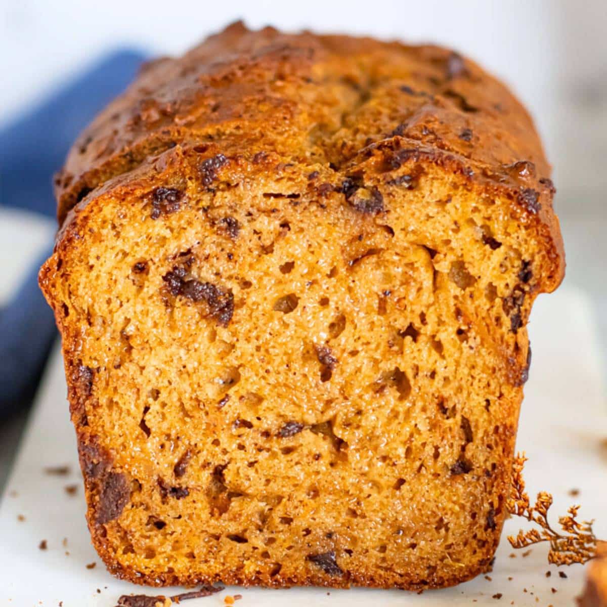 Sliced sweet potato bread with dark chocolate chunks showing moist texture and warm golden crumb.