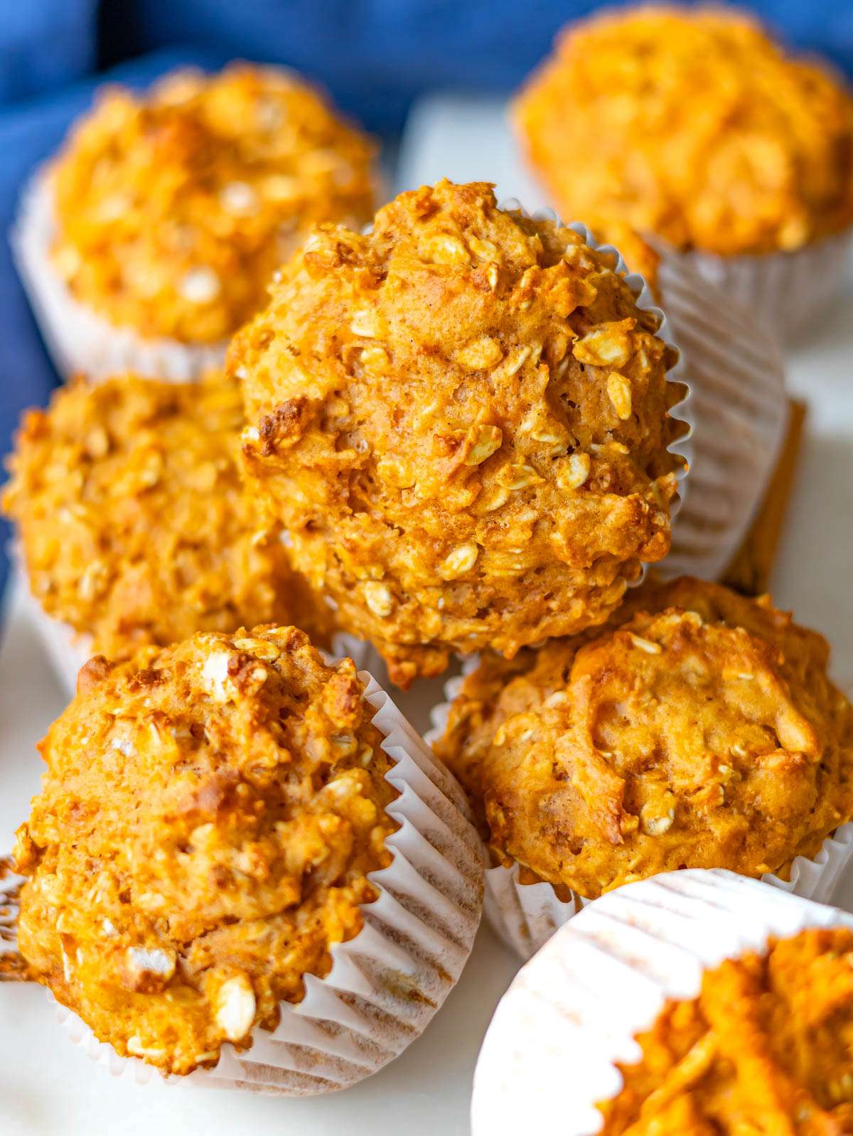 Stack of healthy sweet potato oatmeal muffins topped with visible oats for added texture.