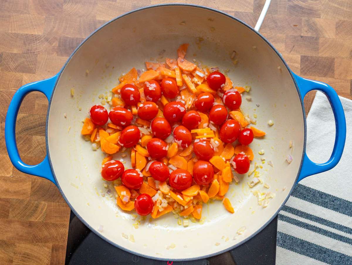 Step 1 Cooking onion carrots and cherry tomatoes in a pot for lentil and orzo base.