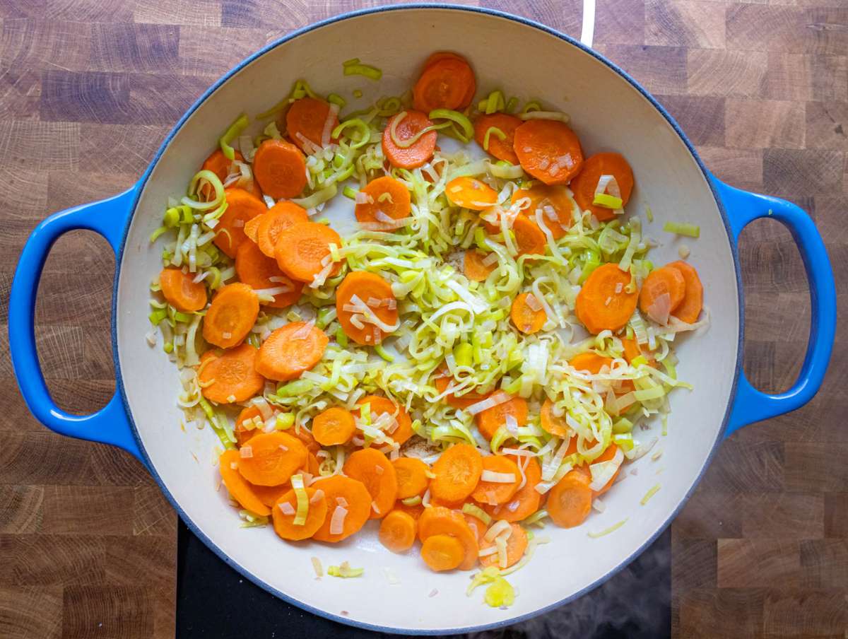 Step 1 Sautéing onion carrot and leek in olive oil in a large pot.