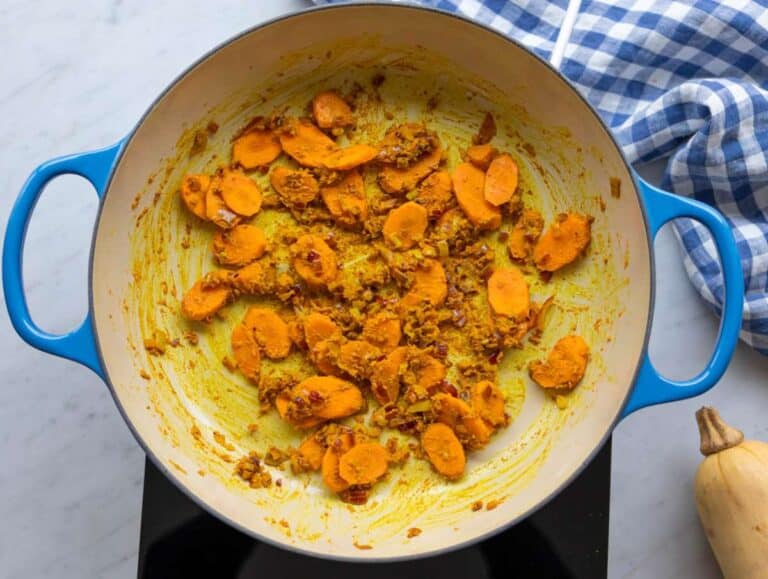 Step 1 Sautéing onion carrots garlic and spices to start curried red lentil soup.