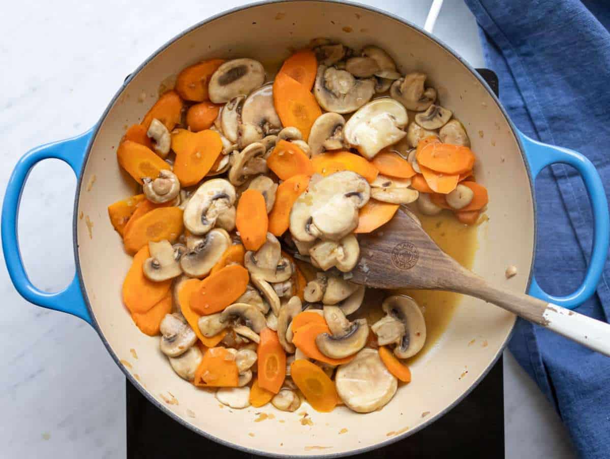 Step 1 Step sautéing onion carrots and mushrooms for Mediterranean three bean orzo soup.