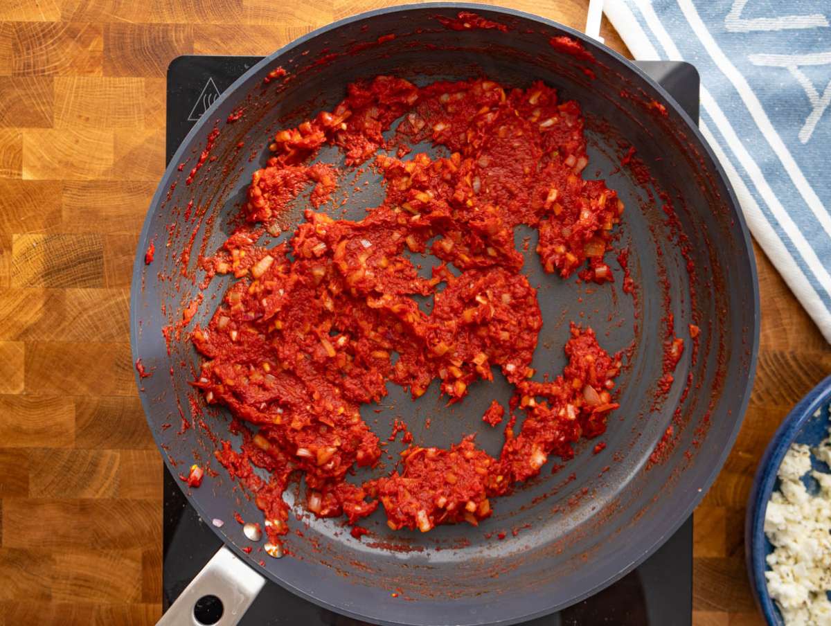 Step 2 Onions garlic and tomato paste sautéing in skillet for flavorful base.