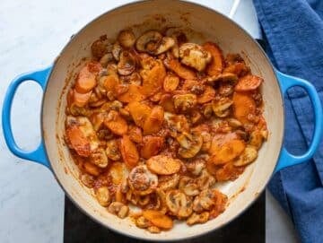 Step 2 Step cooking garlic herbs and tomato paste to deepen flavor for orzo bean soup.