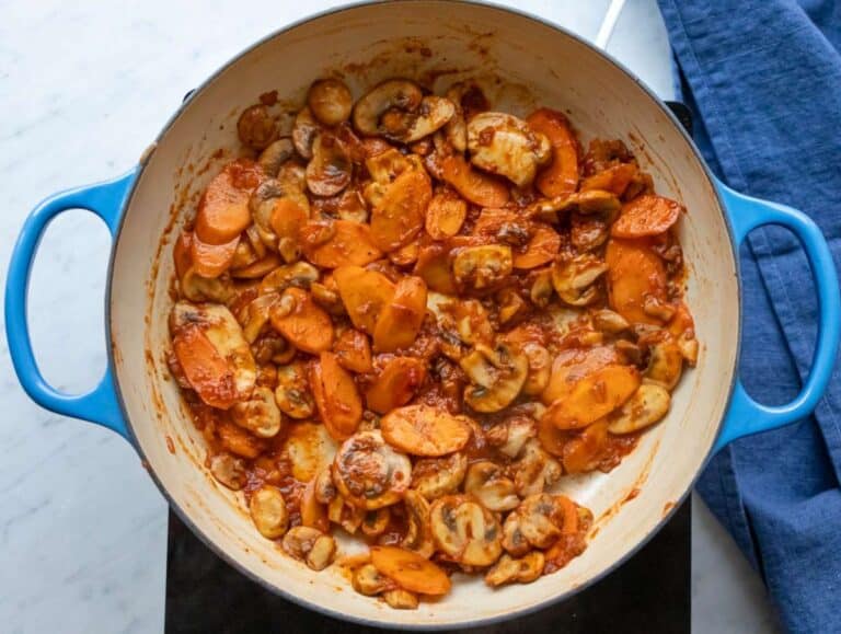 Step 2 Step cooking garlic herbs and tomato paste to deepen flavor for orzo bean soup.