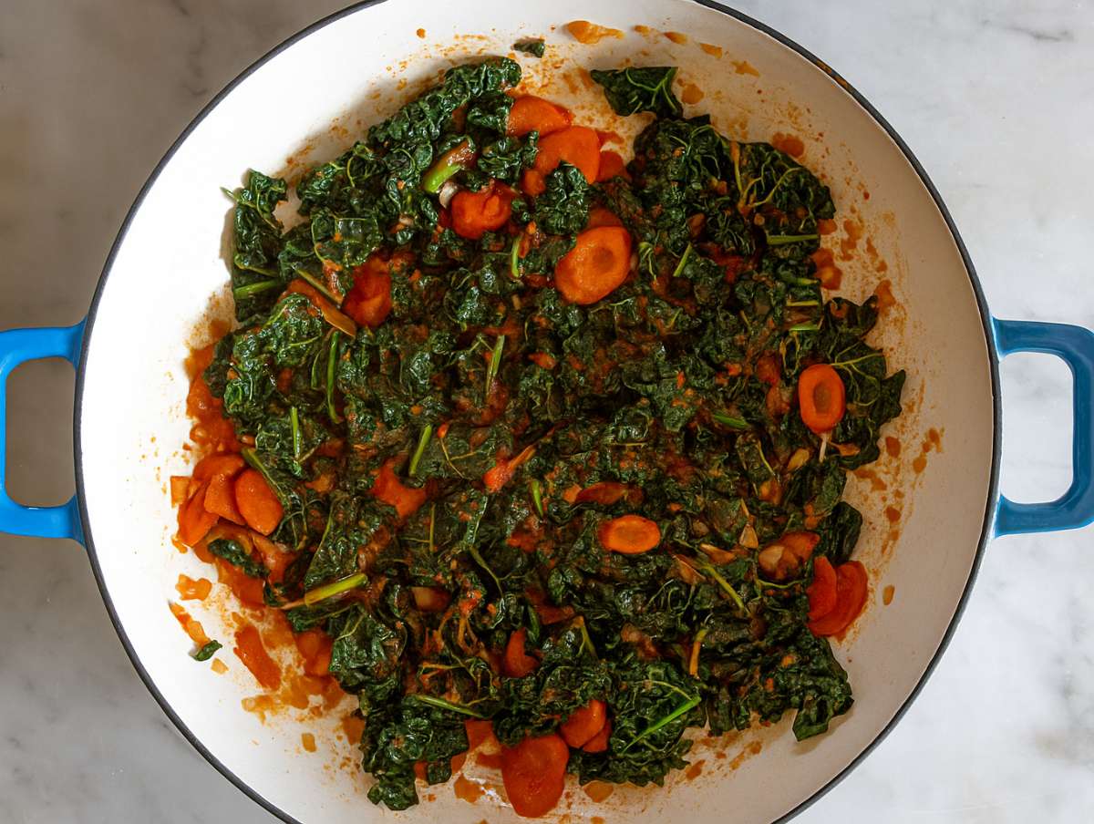 Step 2 Stirring tomato paste rosemary and garlic in skillet for Mediterranean orzo recipe.