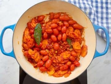 Step 2 cooking garlic herbs and tomato paste to deepen Mediterranean flavors.