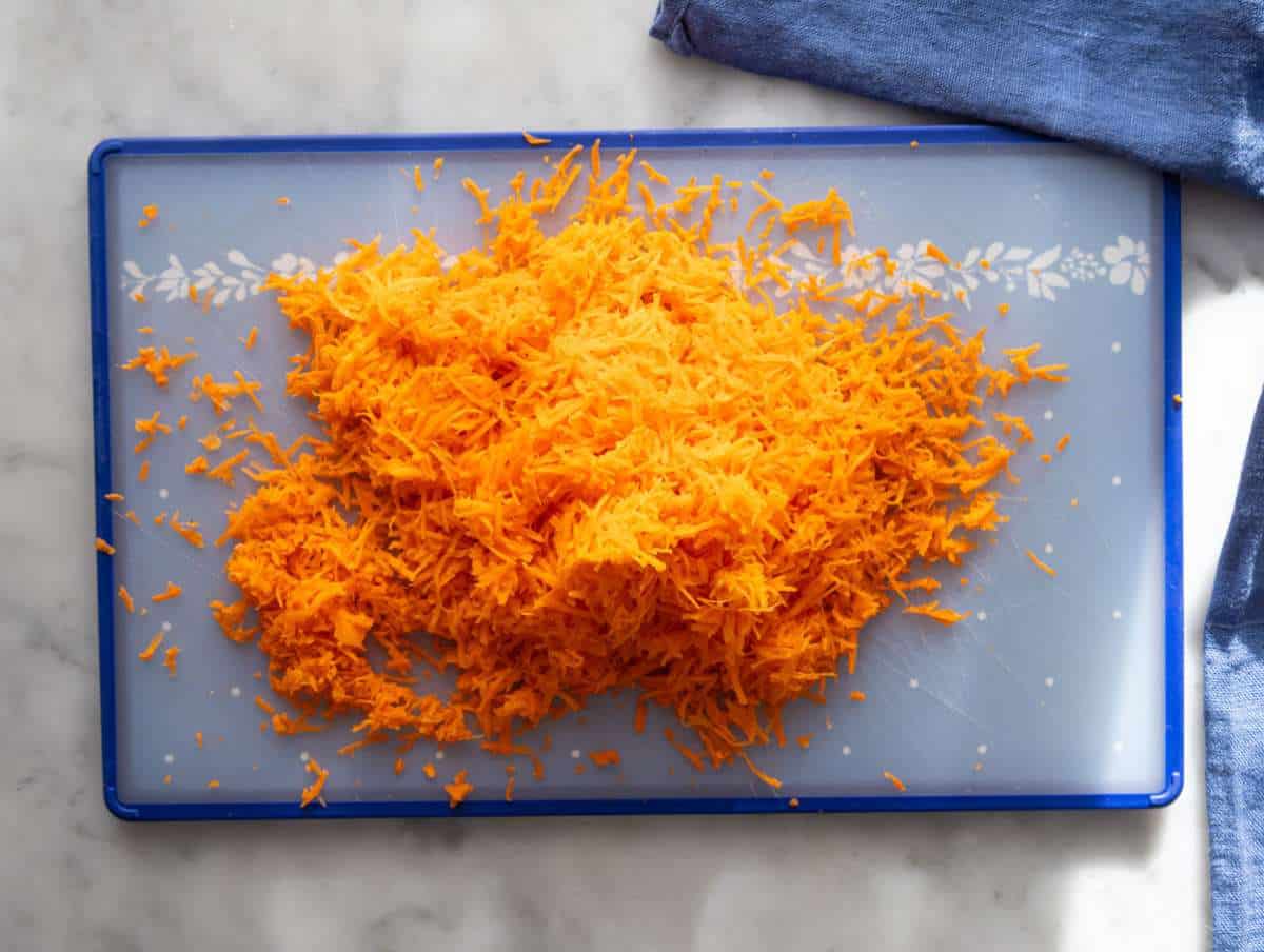 Step 2 finely grated carrots prepared for wholesome carrot cake muffins.