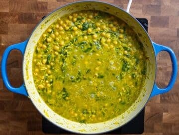Step 3 Stirring basmati rice and chickpeas in fragrant broth for a creamy one pot Mediterranean recipe.