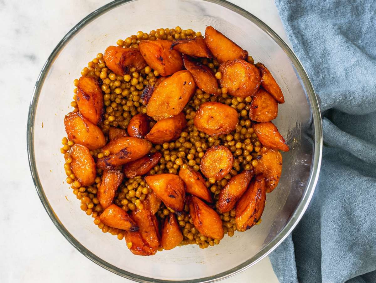 Step 3 Warm roasted carrots added to bowl with lentils before adding parsley and raisins.