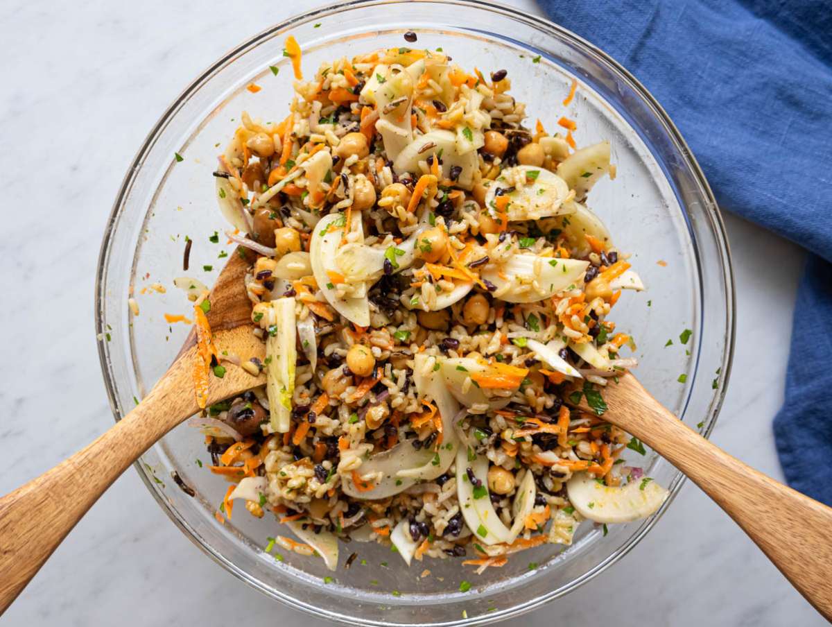 Step 3 chopped vegetables for wild rice salad in a mixing bowl with dressing and chickpeas.