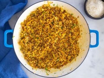 Step 3 – stirring in canned lentils and cooked rice with herbs in large pan.
