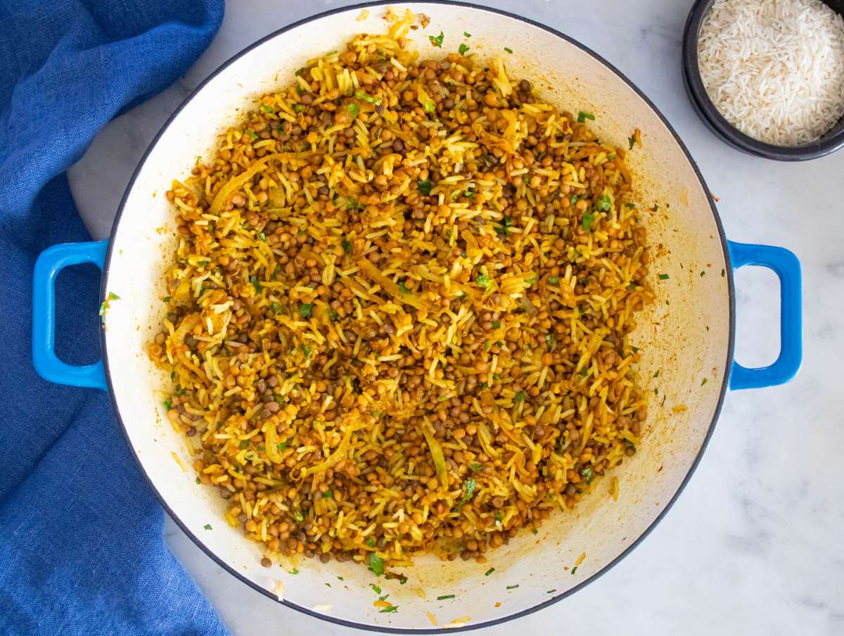 Step 3 – stirring in canned lentils and cooked rice with herbs in large pan.
