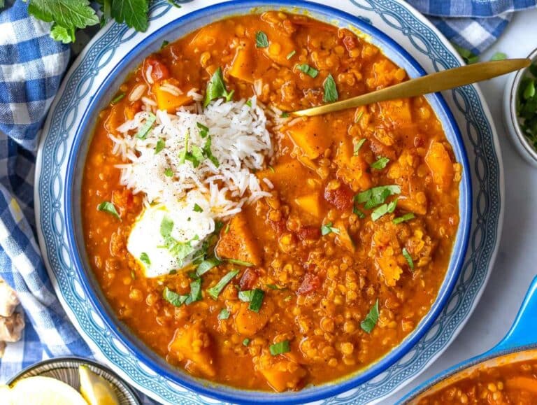 Step 4 Curried lentil soup served in a bowl with greek yogurt lemon herbs and rice.
