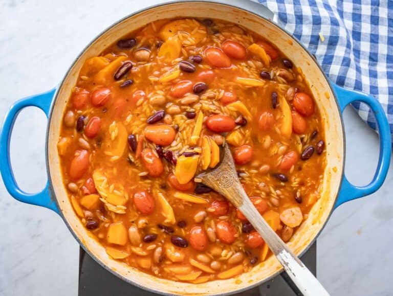 Step 4 adding orzo to simmering pot for creamy one pot orzo recipe.