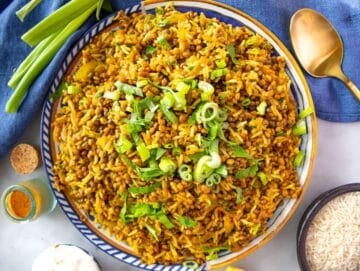 Step 4 – finishing Mediterranean lentils and rice with lemon juice and fresh parsley.