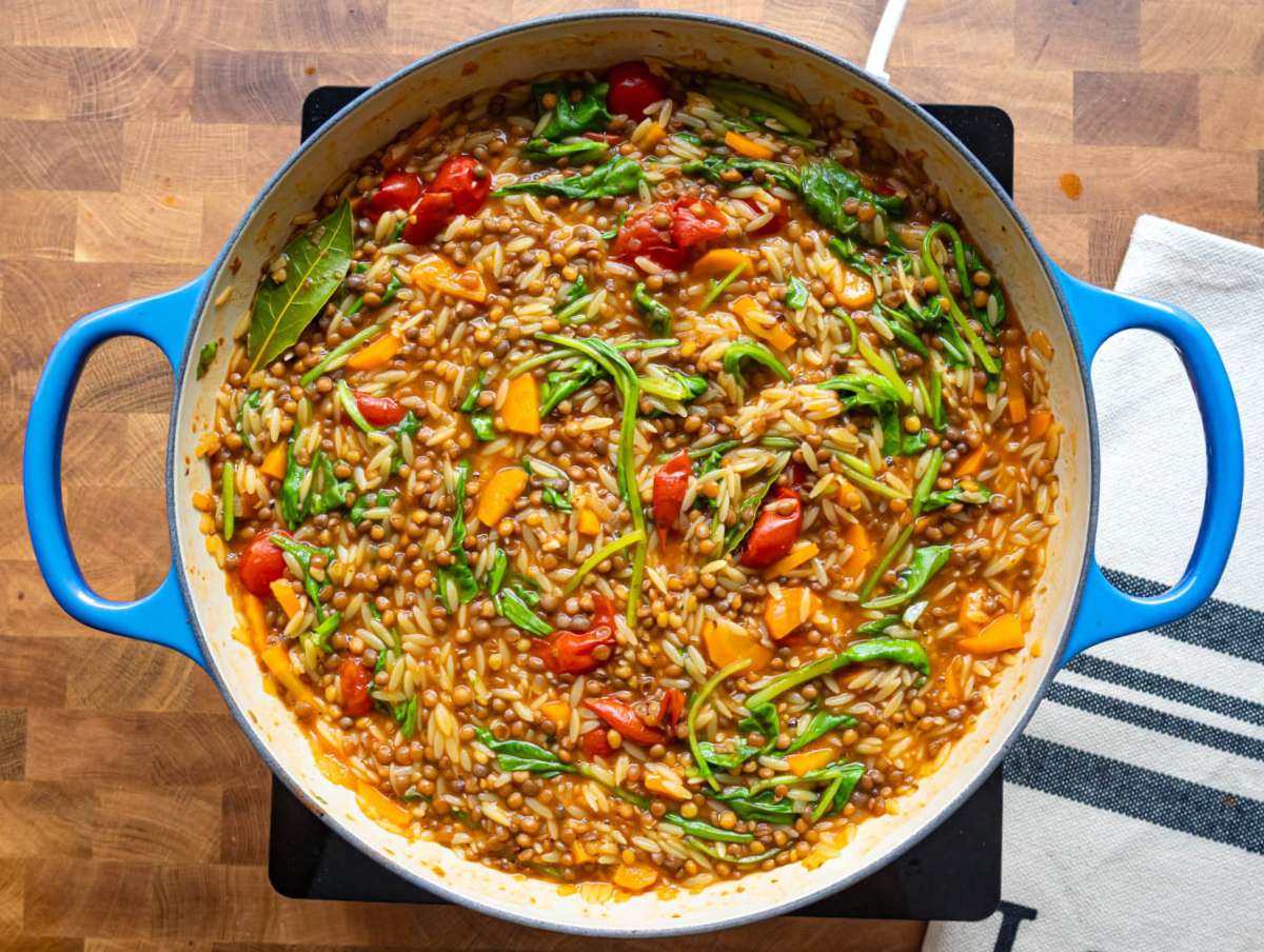 Step 5 Adding spinach to the pot to finish the creamy lentil and orzo recipe.