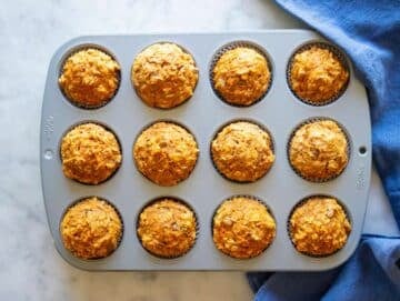 Step 5 baked muffins cooling in muffin pan after coming out of oven.