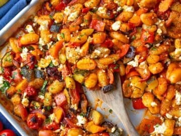 Step four serving roasted gnocchi vegetables with lemon parsley and feta topping.