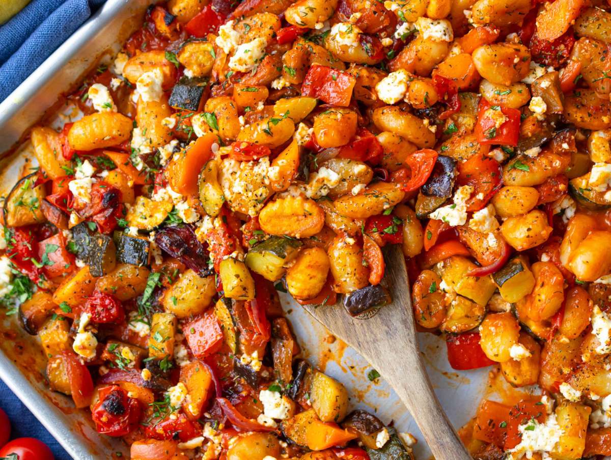 Step four serving roasted gnocchi vegetables with lemon parsley and feta topping.
