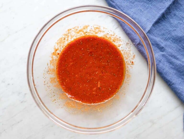 Step one mixing olive oil tomato paste broth and spices in large bowl.